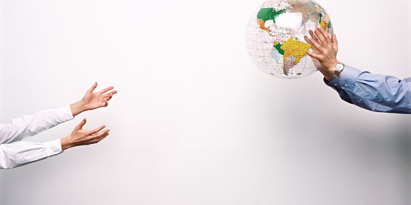 Two men throw a plastic globe to one another