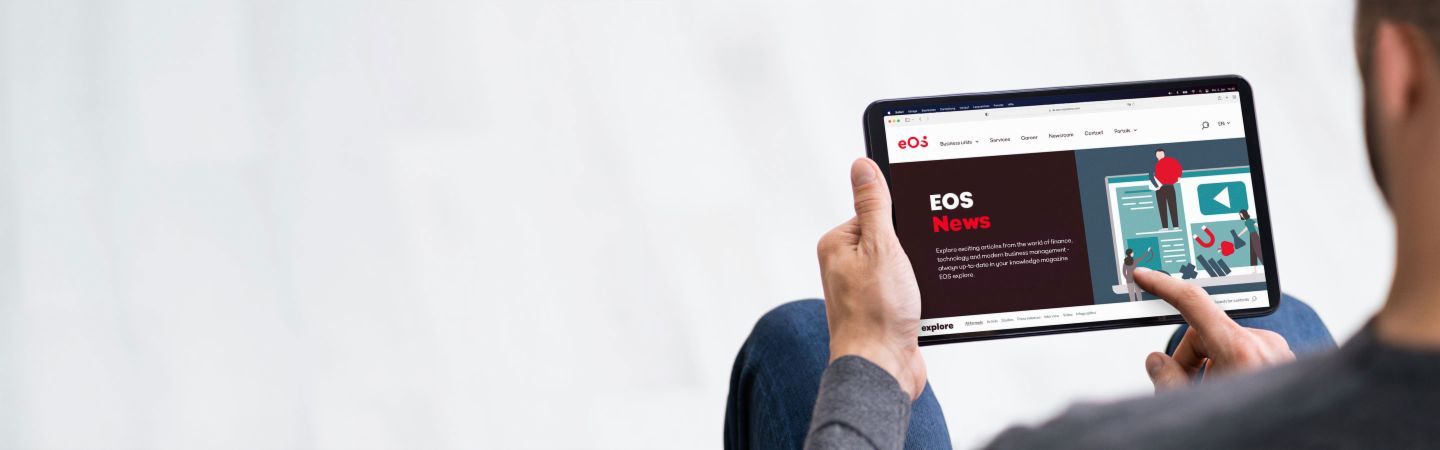 En person holder en tablet, hvor EOS Newsrooms hjemmeside er åben, og giver information om de seneste nyheder, online artikler og pressemeddelelser.