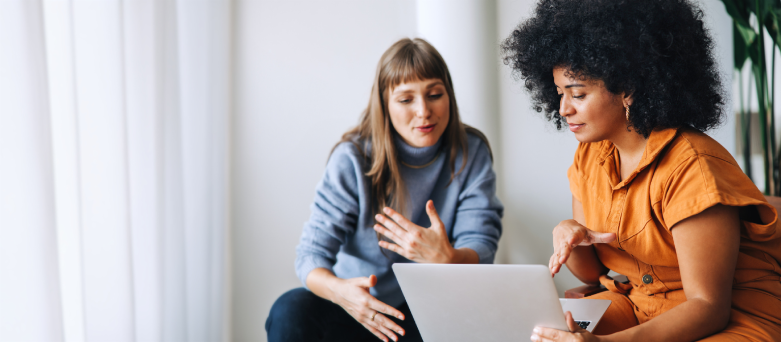 Mladá žena na mobilním telefonu vedle člena týmu EOS s sluchátky a dvěma ženami, které si povídají.