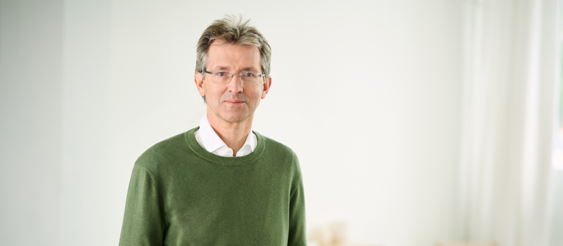 Justus Hecking-Veltman, izvršni direktor finansija, u zelenom džemperu i bijeloj košulji stoji u svijetloj prostoriji.